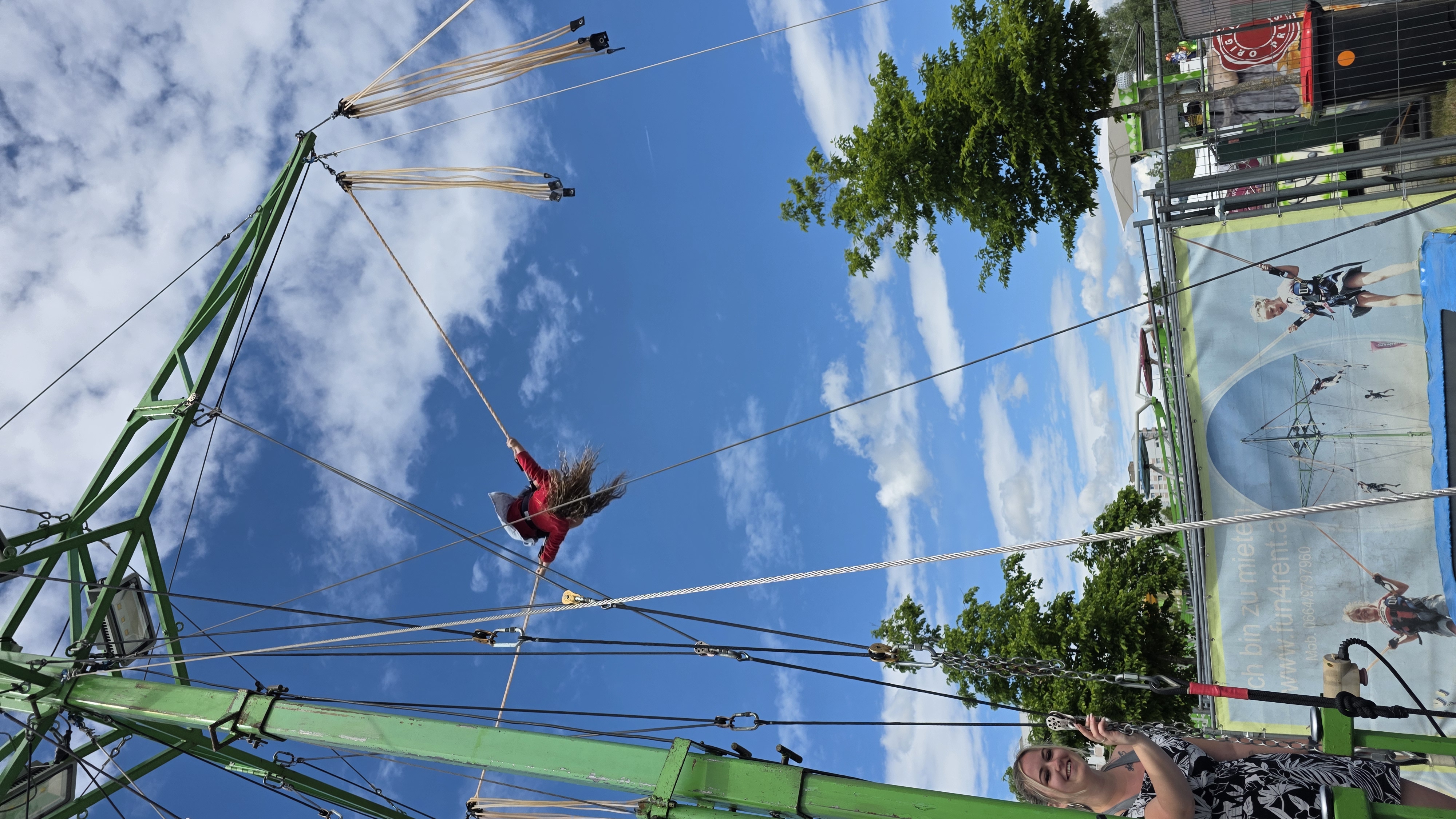 Grünes Bungee-Trampolin vor blauem Himmel